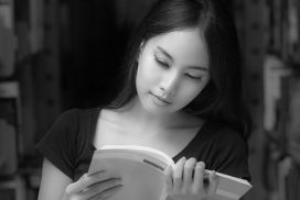 A portrait of a mixed race college asia student at campus in library and read a book