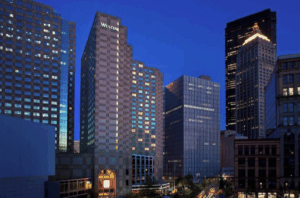 Exterior shot of the Westin Pittsburgh: Tall tower at night in a city with the words WESTIN in lights at the top