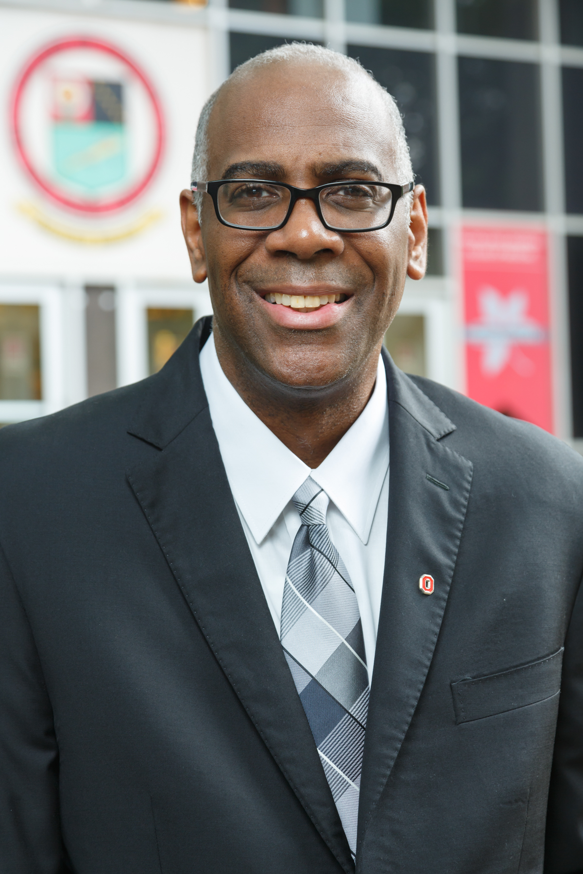 Dr. Leon McDougle in a black suit and plaid blue tie